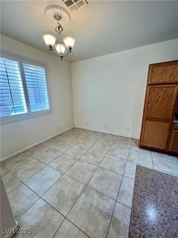 6545 Netherseal Ave, Las Vegas, NV 89139 - unfurnished room with a chandelier, light tile patterned floors, and baseboards