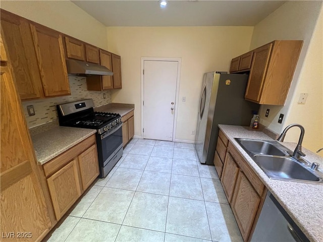 6545 Netherseal Ave, Las Vegas, NV 89139 - kitchen featuring appliances with stainless steel finishes, under cabinet range hood, tasteful backsplash, brown cabinets, and light tile patterned flooring