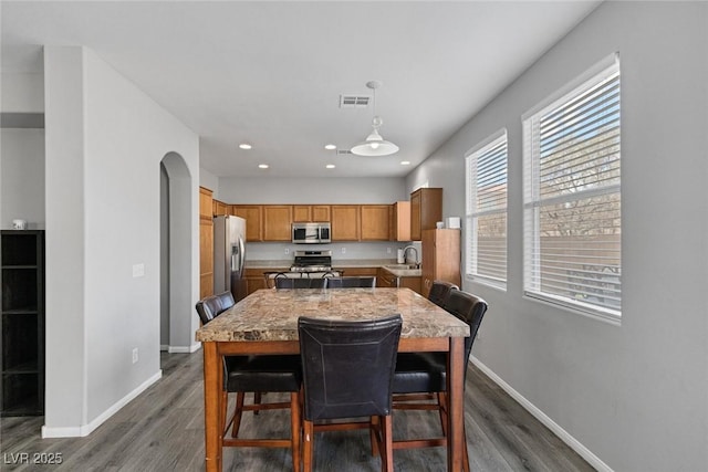 dining space featuring baseboards, dark wood-type flooring, and recessed lighting