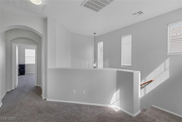 corridor featuring carpet flooring, an upstairs landing, plenty of natural light, and baseboards