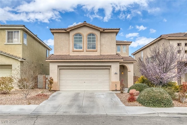 mediterranean / spanish home with concrete driveway, an attached garage, a tiled roof, and stucco siding