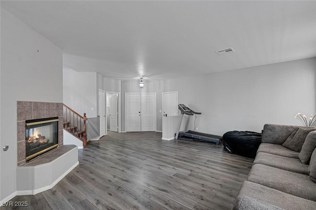 living room with wood finished floors, a fireplace, and baseboards