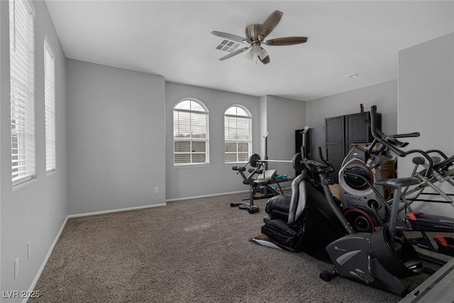 exercise area featuring a ceiling fan, baseboards, and carpet flooring