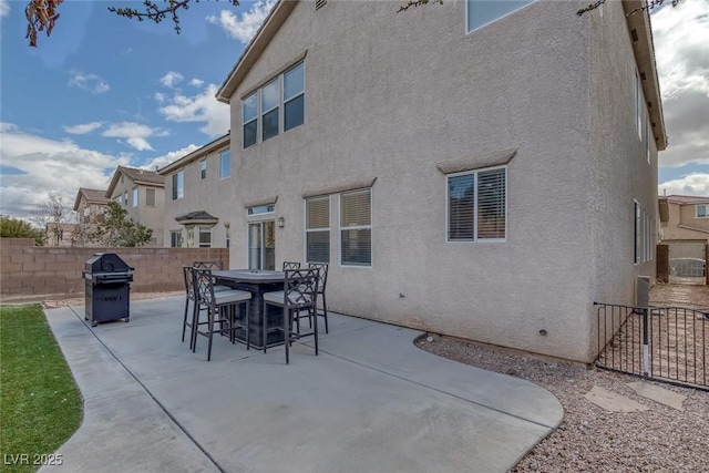 view of patio with a grill, fence, and outdoor dining space