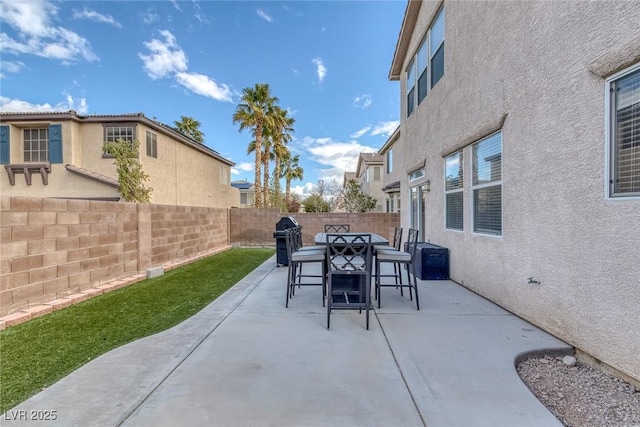 view of patio with outdoor dining space, a fenced backyard, and grilling area