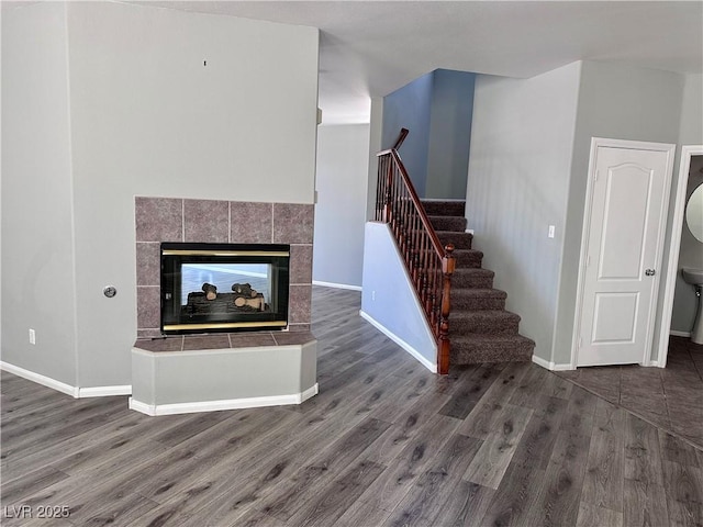 3964 Irvin Ave, Las Vegas, NV 89141 - unfurnished living room featuring wood finished floors, stairs, and a tiled fireplace