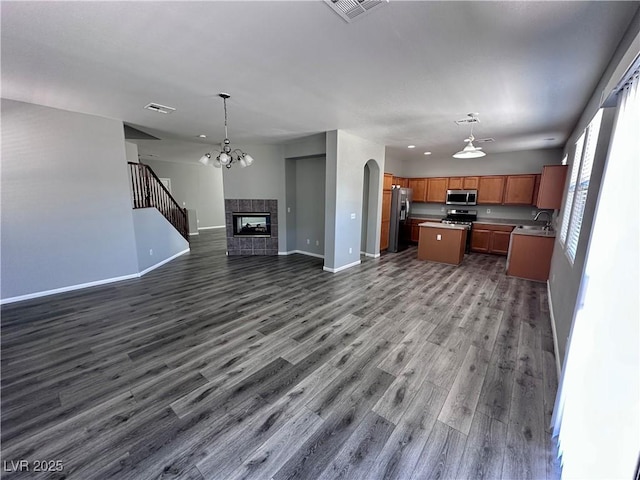3964 Irvin Ave, Las Vegas, NV 89141 - kitchen featuring open floor plan, stainless steel appliances, a center island, dark wood-style floors, and brown cabinetry