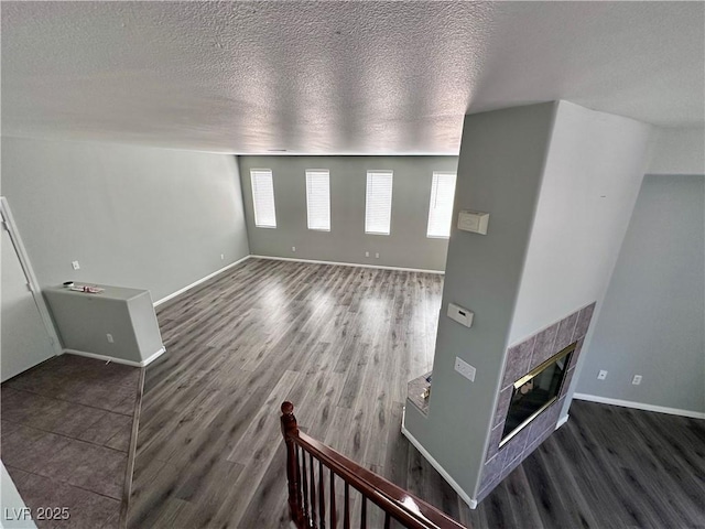 3964 Irvin Ave, Las Vegas, NV 89141 - unfurnished living room featuring wood finished floors, a fireplace, and a textured ceiling