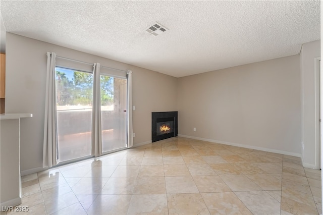 3150 Soft Breezes Dr Unit 1216, Las Vegas, NV 89128 - unfurnished living room featuring a textured ceiling, a glass covered fireplace, light tile patterned flooring, and baseboards
