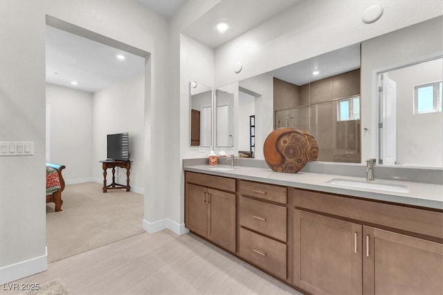 full bathroom with a shower stall, wood finished floors, baseboards, double vanity, and recessed lighting