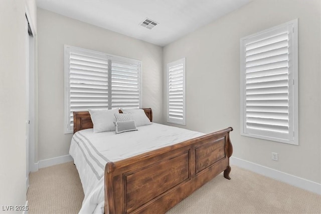 bedroom featuring light colored carpet and baseboards