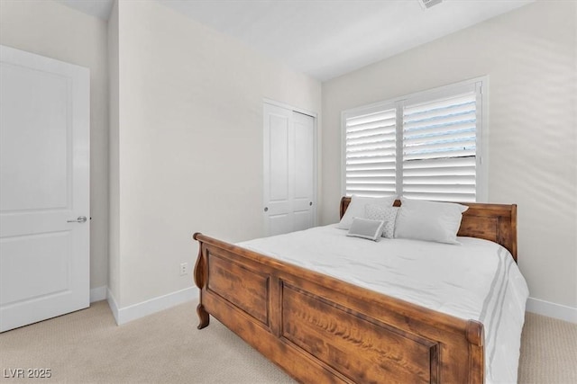 bedroom featuring baseboards, light carpet, and a closet