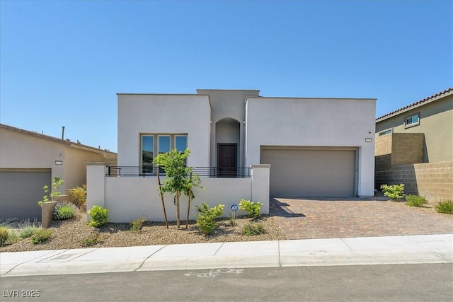 11707 Hatchling Ave, Las Vegas, NV 89138 - view of front of home featuring an attached garage, stucco siding, decorative driveway, and fence