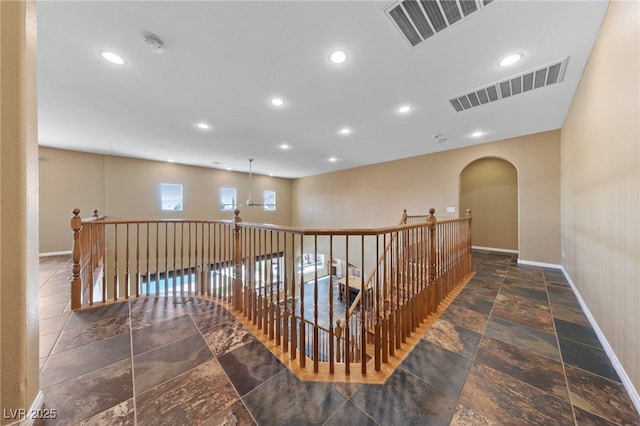 8547 Benidorm Ave, Las Vegas, NV 89178 - hall with baseboards, recessed lighting, stone tile flooring, arched walkways, and an upstairs landing