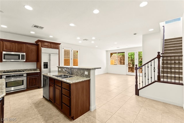 1252 Casa Palermo Cir, Henderson, NV 89011 - kitchen with appliances with stainless steel finishes, a sink, recessed lighting, an island with sink, and light tile patterned floors