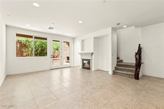 1252 Casa Palermo Cir, Henderson, NV 89011 - unfurnished living room featuring light tile patterned floors, stairs, recessed lighting, a glass covered fireplace, and baseboards