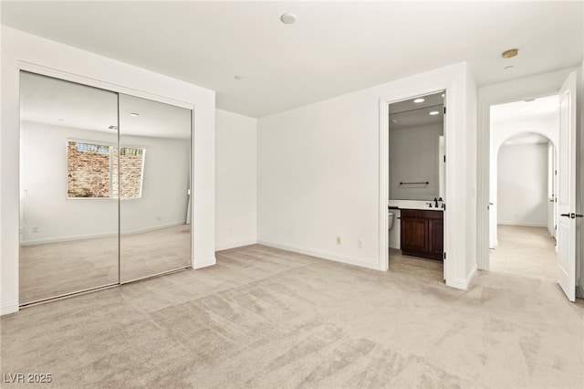 1252 Casa Palermo Cir, Henderson, NV 89011 - unfurnished bedroom featuring light carpet, arched walkways, a closet, baseboards, and recessed lighting