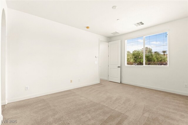 1252 Casa Palermo Cir, Henderson, NV 89011 - empty room featuring light colored carpet, baseboards, and arched walkways