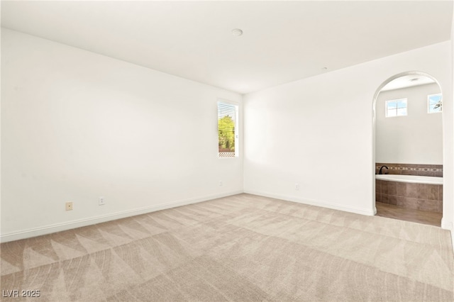 1252 Casa Palermo Cir, Henderson, NV 89011 - empty room featuring carpet floors, plenty of natural light, arched walkways, and baseboards