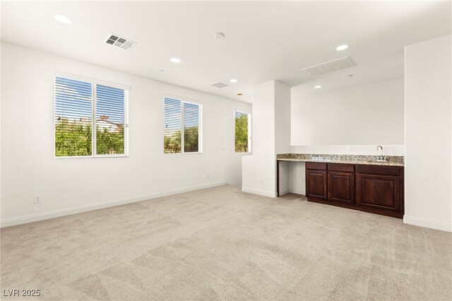 1252 Casa Palermo Cir, Henderson, NV 89011 - unfurnished living room featuring light colored carpet, recessed lighting, baseboards, and a sink