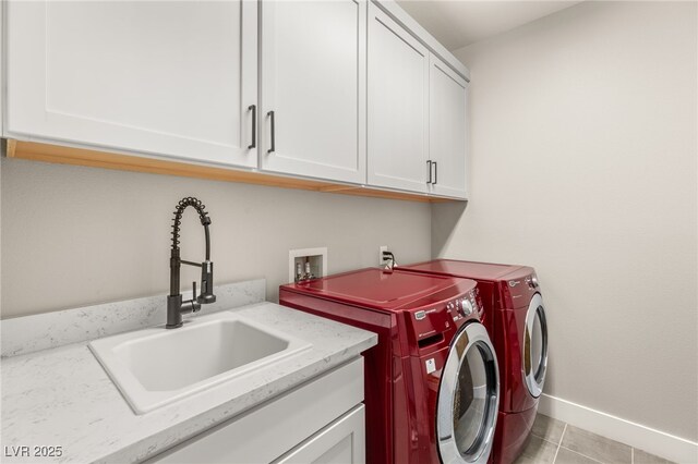 clothes washing area with cabinet space, washing machine and dryer, baseboards, and light tile patterned floors