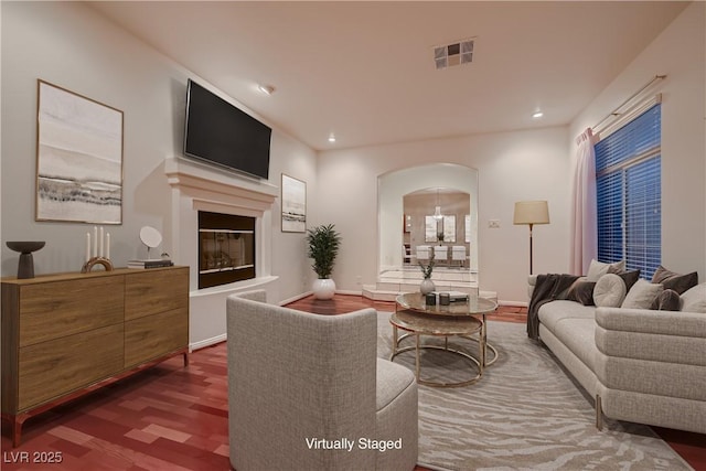 386 Wiseton Ave, Las Vegas, NV 89183 - living room with wood finished floors, arched walkways, recessed lighting, a glass covered fireplace, and baseboards