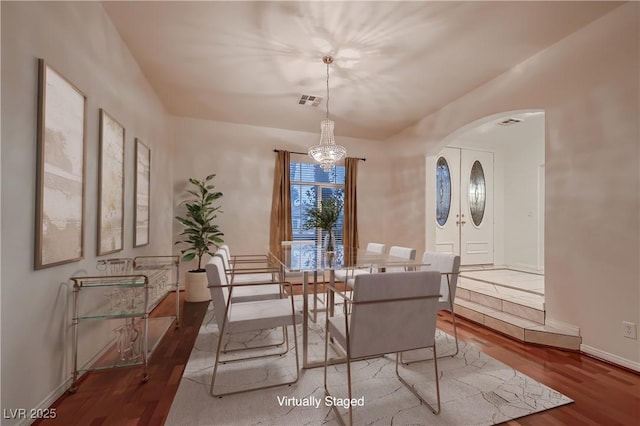 386 Wiseton Ave, Las Vegas, NV 89183 - dining area featuring arched walkways, wood finished floors, a chandelier, and baseboards