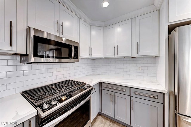 11028 Meadow Leaf Ave, Las Vegas, NV 89144 - kitchen featuring stainless steel appliances, gray cabinets, light stone counters, and backsplash