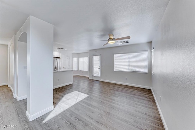 11028 Meadow Leaf Ave, Las Vegas, NV 89144 - unfurnished living room with a ceiling fan, light wood-style flooring, and baseboards