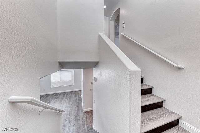 11028 Meadow Leaf Ave, Las Vegas, NV 89144 - staircase featuring wood finished floors, baseboards, arched walkways, and a textured wall