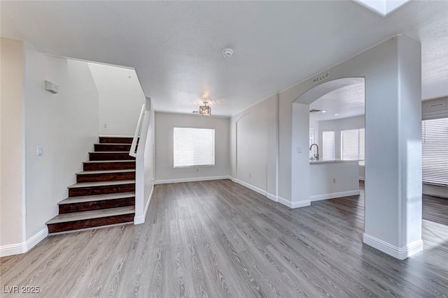11028 Meadow Leaf Ave, Las Vegas, NV 89144 - stairway with arched walkways, wood finished floors, and plenty of natural light