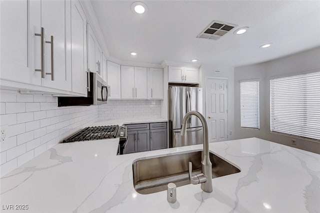 11028 Meadow Leaf Ave, Las Vegas, NV 89144 - kitchen featuring stainless steel appliances, white cabinetry, a sink, decorative backsplash, and recessed lighting