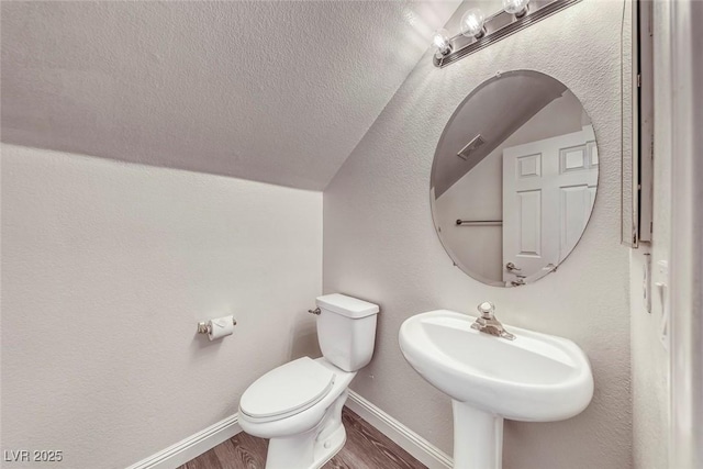 11028 Meadow Leaf Ave, Las Vegas, NV 89144 - half bathroom with baseboards, wood finished floors, toilet, lofted ceiling, and a sink