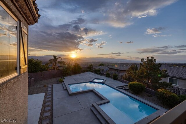 2900 Valvent Ct, Henderson, NV 89044 - pool at dusk with a patio area, a pool with connected hot tub, and a fenced backyard