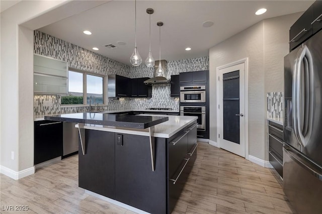 2900 Valvent Ct, Henderson, NV 89044 - kitchen featuring appliances with stainless steel finishes, wall chimney exhaust hood, a kitchen island, backsplash, and a sink