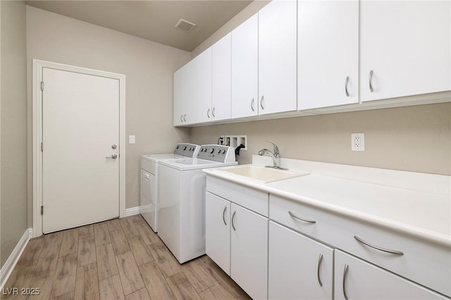 2900 Valvent Ct, Henderson, NV 89044 - laundry area with washing machine and dryer, cabinet space, light wood-type flooring, and baseboards