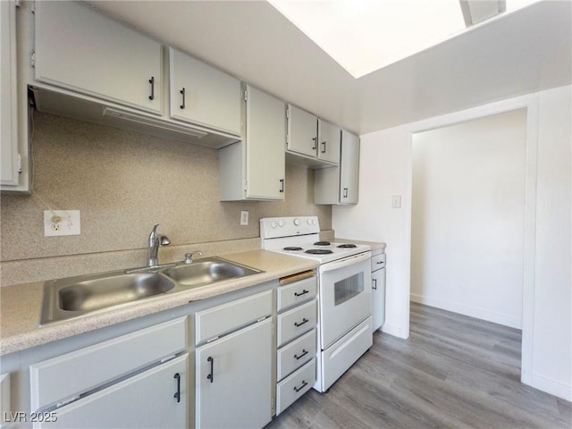 26 E Atlantic Ave, Henderson, NV 89015 - kitchen with white range with electric cooktop, light countertops, light wood finished floors, a sink, and baseboards