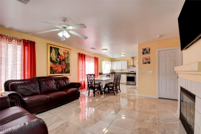 8370 Lost Lake Ct, Las Vegas, NV 89147 - living room with a ceiling fan, a tiled fireplace, light marble finish flooring, and baseboards