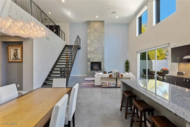 2672 Mystere Ct, Las Vegas, NV 89117 - dining area with a towering ceiling, stairway, concrete floors, a tiled fireplace, and recessed lighting