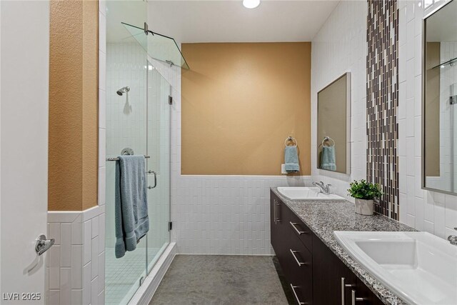 2672 Mystere Ct, Las Vegas, NV 89117 - bathroom with tile walls, double vanity, a shower stall, and a wainscoted wall