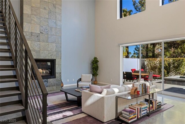 2672 Mystere Ct, Las Vegas, NV 89117 - living room featuring stairs, plenty of natural light, a high ceiling, and a tiled fireplace