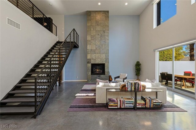2672 Mystere Ct, Las Vegas, NV 89117 - living room with stairway, a towering ceiling, concrete flooring, recessed lighting, and a fireplace