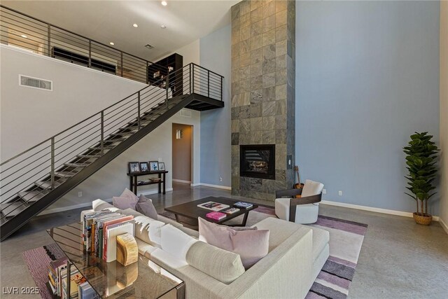 2672 Mystere Ct, Las Vegas, NV 89117 - living room featuring a towering ceiling, stairway, a fireplace, and recessed lighting