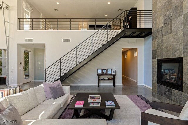 2672 Mystere Ct, Las Vegas, NV 89117 - living room with a high ceiling, a fireplace, stairs, and recessed lighting