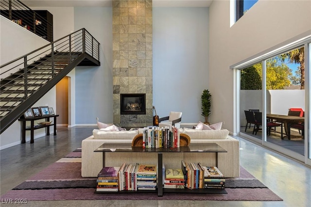 2672 Mystere Ct, Las Vegas, NV 89117 - living room featuring finished concrete floors, a fireplace, stairway, and a high ceiling