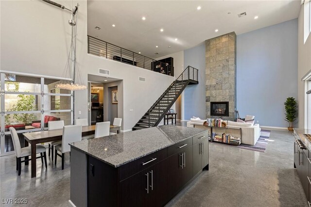 2672 Mystere Ct, Las Vegas, NV 89117 - kitchen with a high ceiling, a center island, a large fireplace, concrete flooring, and recessed lighting