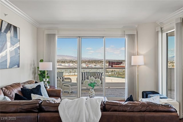 living room with healthy amount of natural light, ornamental molding, and a mountain view
