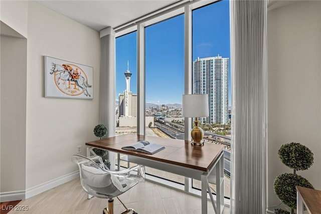 office space with a city view, expansive windows, and baseboards