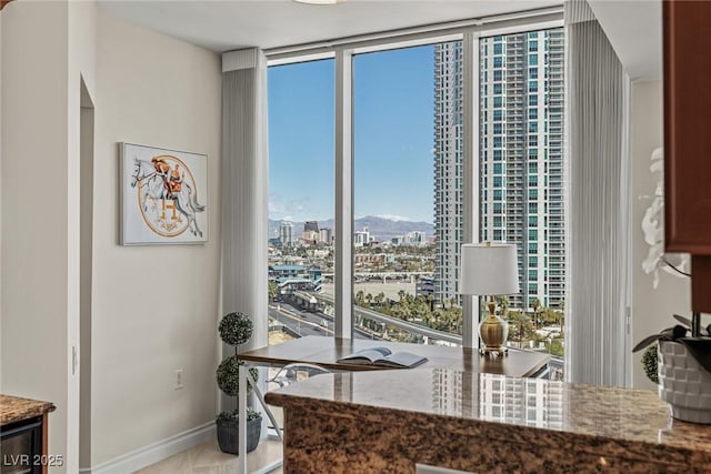 2777 Paradise Rd Unit 1105, Las Vegas, NV 89109 - office with healthy amount of natural light, a wall of windows, a city view, and baseboards