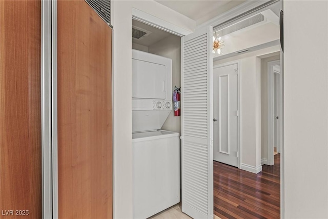 2777 Paradise Rd Unit 1105, Las Vegas, NV 89109 - washroom featuring stacked washing machine and dryer, light wood finished floors, and baseboards